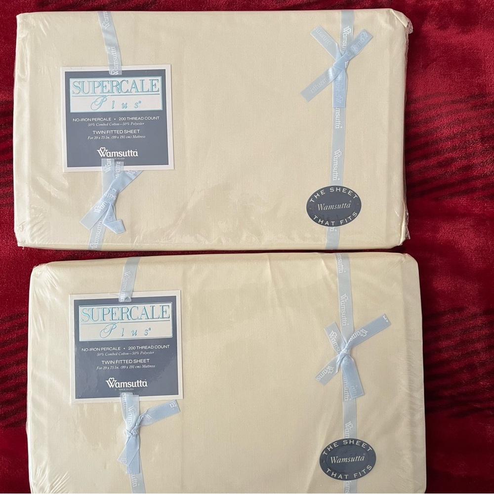 Set of two new twin fitted sheets in original packaging. Cream colored
